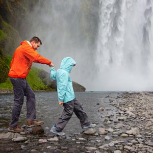 Far og søn besøger vandfaldet Skogafoss på Island